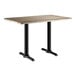 A rectangular standard height table with a gray wood finish top and black metal legs.