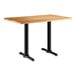 A Lancaster Table & Seating rectangular table with black legs and a maple finish top.