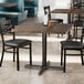 A Lancaster Table & Seating square table with a dark walnut finish and four chairs in a restaurant dining area.