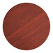 A Lancaster Table & Seating round wooden table top with a red mahogany finish.