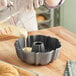 A woman pouring batter into a Nordic Ware Bundt cake pan.