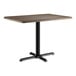 A Lancaster Table & Seating rectangular table with a dark walnut top and black base.