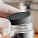 A person holding a jar with a black 53/400 polypropylene cap.