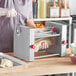 A woman using an Estella manual turnover machine to make dough.