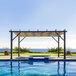 A pool with a Paragon Outdoor Modena aluminum pergola with a retractable canopy over it.