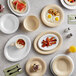 A table set with Acopa white wide rim melamine plates, bowls of food, and drinks.