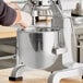 A person using a MainStreet Equipment stainless steel bowl to mix food in a Galaxy mixer.