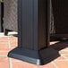 A black metal post on a brick surface with a Paragon Outdoor Santa Monica gazebo base.