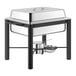 An Acopa stainless steel chafing dish with a black wrought iron stand and cover on a table.