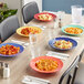 Assorted Acopa Foundations melamine pasta bowls on a table with pasta plates.