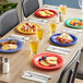 A table with Acopa Foundations melamine plates of food and drinks on it.