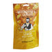 A yellow and orange bag of Mixologist's Garden freeze-dried lemon slices with a man holding a glass of lemon.