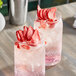 Two glasses of liquid with ice and freeze-dried strawberry slices.