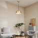 A living room with a white couch and a Globe Novogratz Retro Matte Brass pendant light.