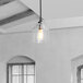 A Globe matte black pendant light with a clear glass shade hanging over a kitchen table.