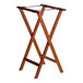 A Lancaster Table & Seating walnut wood folding tray stand with two legs and straps.