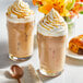 Two iced coffee drinks with whipped cream and Guittard caramel sauce.