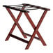 A Lancaster Table & Seating mahogany wood folding luggage rack with two legs.