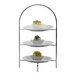 A Hepp by Bauscher stainless steel three tiered display stand with desserts.