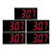 A group of four black digital clocks with red numbers.