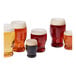 A group of Tossware plastic pint glasses filled with beer.