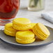 A plate of yellow Coco Bakery Meyer Lemon macarons.