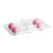 A plastic container with pink Coco Bakery cake pops with white sprinkles.