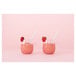 Two Tossware Vino XL glasses filled with strawberry smoothie with white straws.