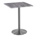 A Holland Bar Stool EnduroTop square table with a metal base and greystone top.