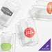 A set of clear, customizable plastic can-shaped glasses with various printed logos.