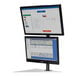 A Newcastle Systems dual monitor holder with two screens on it.