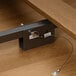 A metal latch on a Lancaster Table & Seating Vineyard Series outdoor folding table with a brown wood top.