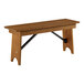 A Lancaster Table & Seating Vineyard Series brown wooden bench with black metal legs.