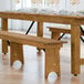 A Lancaster Table & Seating Vineyard Series wooden bench on a table.