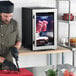 A compact dry aging cabinet with a glass door, designed for aging meat, shown on a countertop in a kitchen setting.