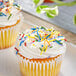 A close-up of a cupcake with Supernatural Rainbow Crunchies sprinkles on top.