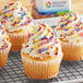 A group of cupcakes with frosting and Supernatural Rainbow Softies sprinkles on a cooling rack.