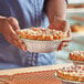 A person holding a Baker's Lane deep foil pie in a tin pan.