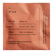 A white Dona Flirt Herbal Tea sachet with black text.