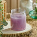 A 12 oz. clear PET jar of purple liquid on a wood slice.