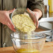 A person pouring De Tulpen Potato Flakes into a bowl.