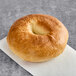 A Just Bagels plain bagel on a white plate.