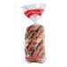 A bag of Just Bagels sundried tomato bagels with red and white labels.