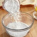 A person pouring De Tulpen cassava flour into a bowl.