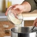 A hand pouring De Tulpen potato flour into a bowl.