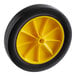 A close up of a yellow wheel with black spokes.