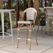 A Lancaster Table & Seating outdoor rattan barstool with a gray and white chevron weave seat.