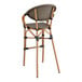 A Lancaster Table & Seating brown Teslin outdoor arm barstool with a black seat and back.