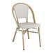 A white chair with a wooden frame and leg with a Lancaster Table & Seating white cushion.