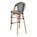 A black and white Lancaster Table & Seating outdoor barstool with a seat back.
